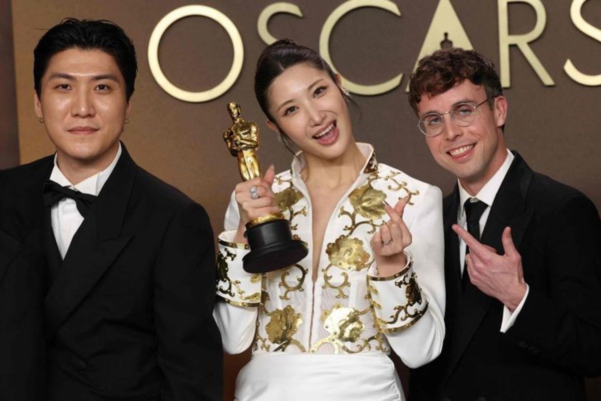 KPop Demon Hunters smiling while holing unto their award
