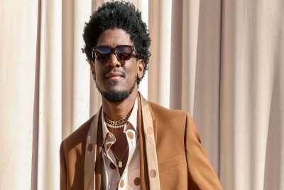 Labrinth in an event wearing a brown jacket