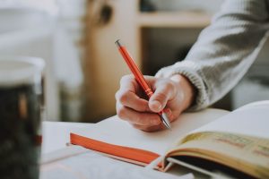Someone journaling indoors illustrating how journaling can improve your life.