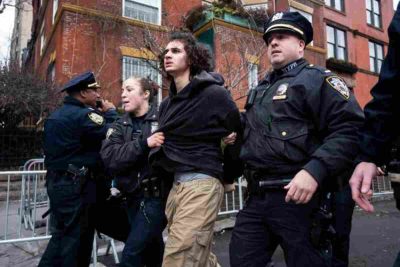 A teenager led by the police in the Two teenagers face charges over an alleged bomb attempt during a protest in New York, raising fresh concerns about security and a possible New York terror threat.