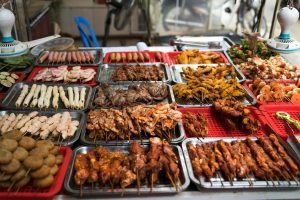 Street food vendor serving local meals, highlighting budget friendly travel tips for saving money on food while traveling.