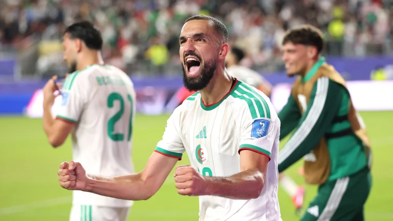 Algeria players celebrating after a 2-1 victory over Jordan in a FIFA World Cup group stage match.