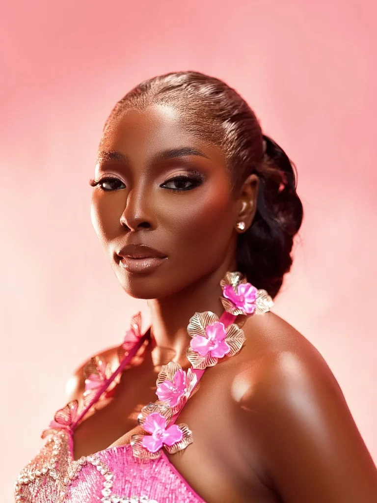 Close-up beauty portrait of Tamunosoye Karibi George showcasing a pink beaded neckline with prominent sculptural 3D pink and silver metallic flowers. Credit: Bella Naija
